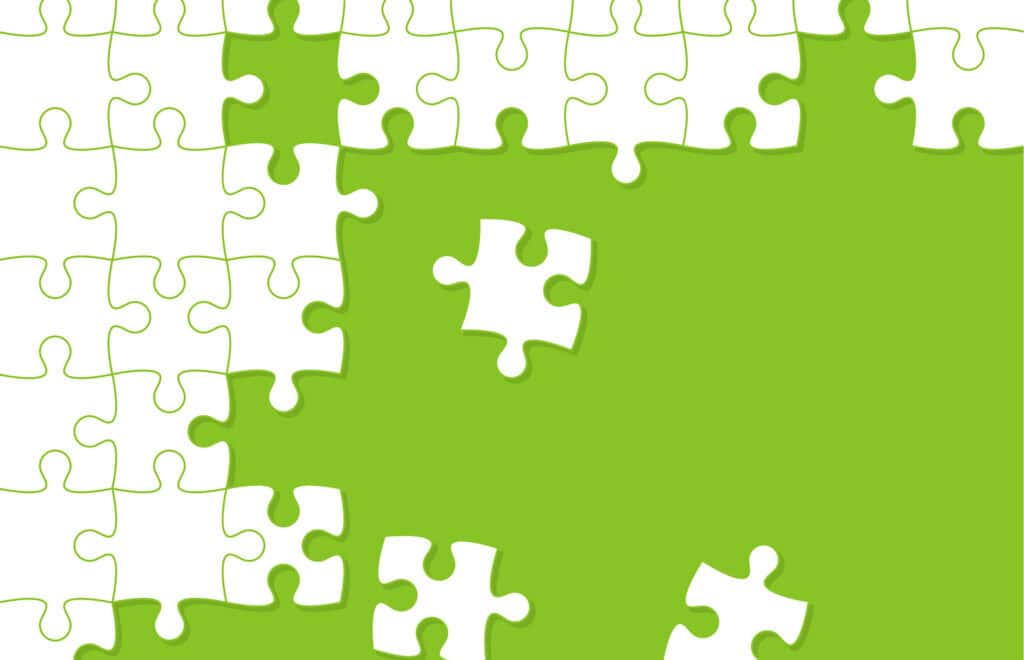 Jigsaw puzzle pieces laid on a green background
