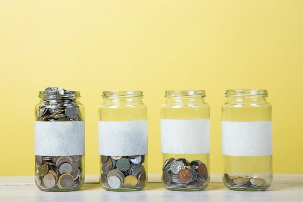 Labeled Glass Jars with coins, varying in amounts of coins